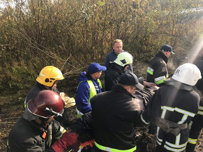Members of emergency services evacuate a wounded person at the site of the Antonov-12 cargo airplane