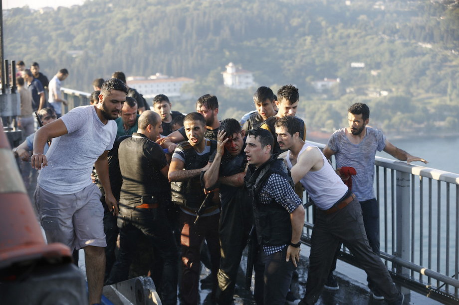 Policemen protect a soldier from a mob after troops involved in the coup surrendered on the Bosporus Bridge in Istanbul on July 16.