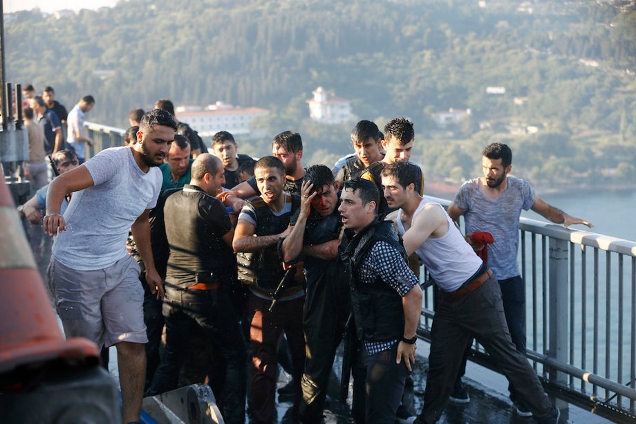 Policemen protect a soldier from a mob after troops involved in the coup surrendered on the Bosporus Bridge in Istanbul on July 16.