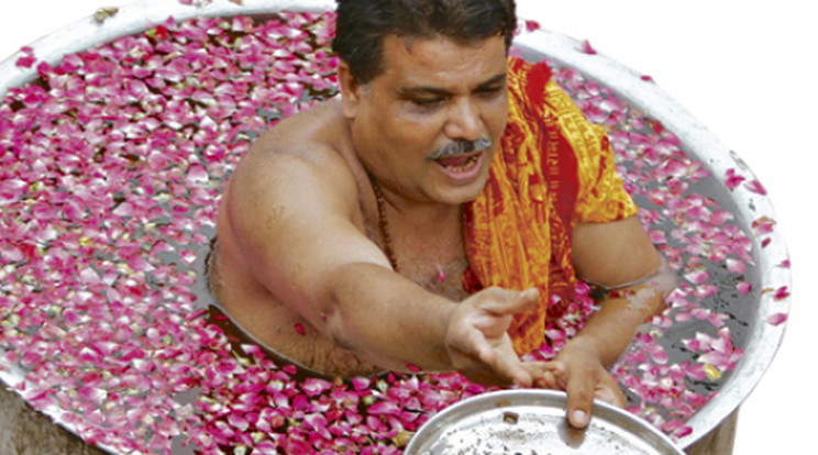 Virágszirmok közé merül a hindu pap az esőért