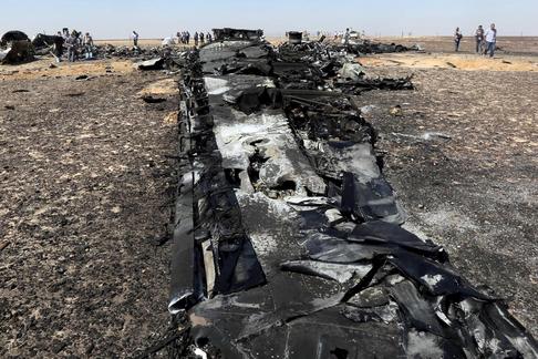 Military investigators from Egypt and Russia stand near the debris of a Russian airliner at the site