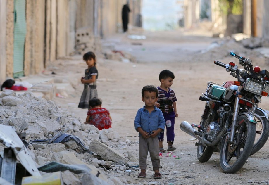 Children play along a street in the rebel-held al-Sheikh Said neighbourhood of Aleppo