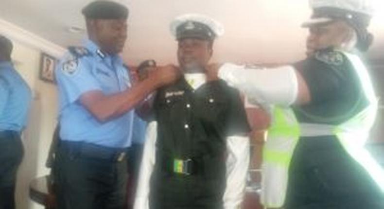 CP Idowu Owohunwa decorating promoted Insp. Ajara Isede of the Lagos Police Traffick Division on Thursday in Lagos. [(NAN]