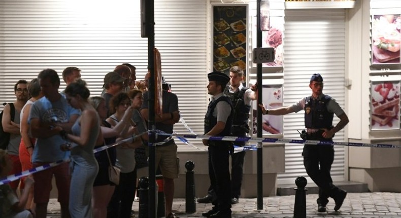 Police officials stand alert as members of the public gather behind a cordon on a street outside Gare Centrale in Brussels, on June 20, 2017