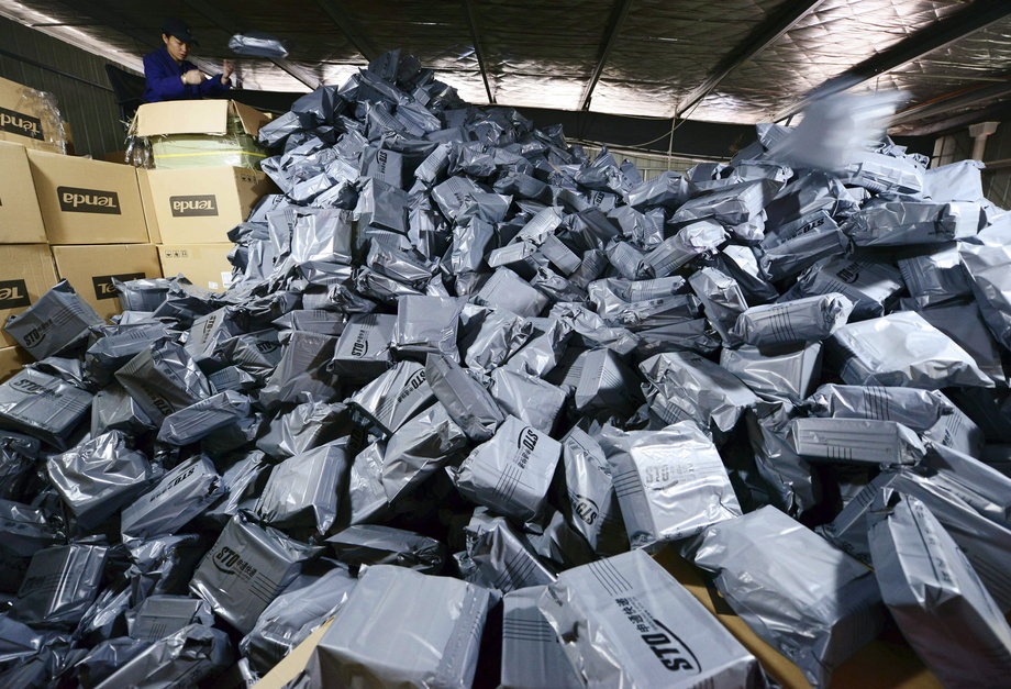 An employee sorts packages at a hub of Shentong (STO) Express delivery company in Jiujiang, Jiangxi province, November 11, 2014.