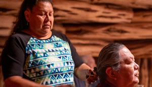 Navajo woman helping her husband braid his hairgrandriver/Getty Images