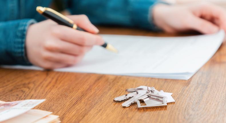 A stock photo shows a person signing a mortgage contract.Getty Images