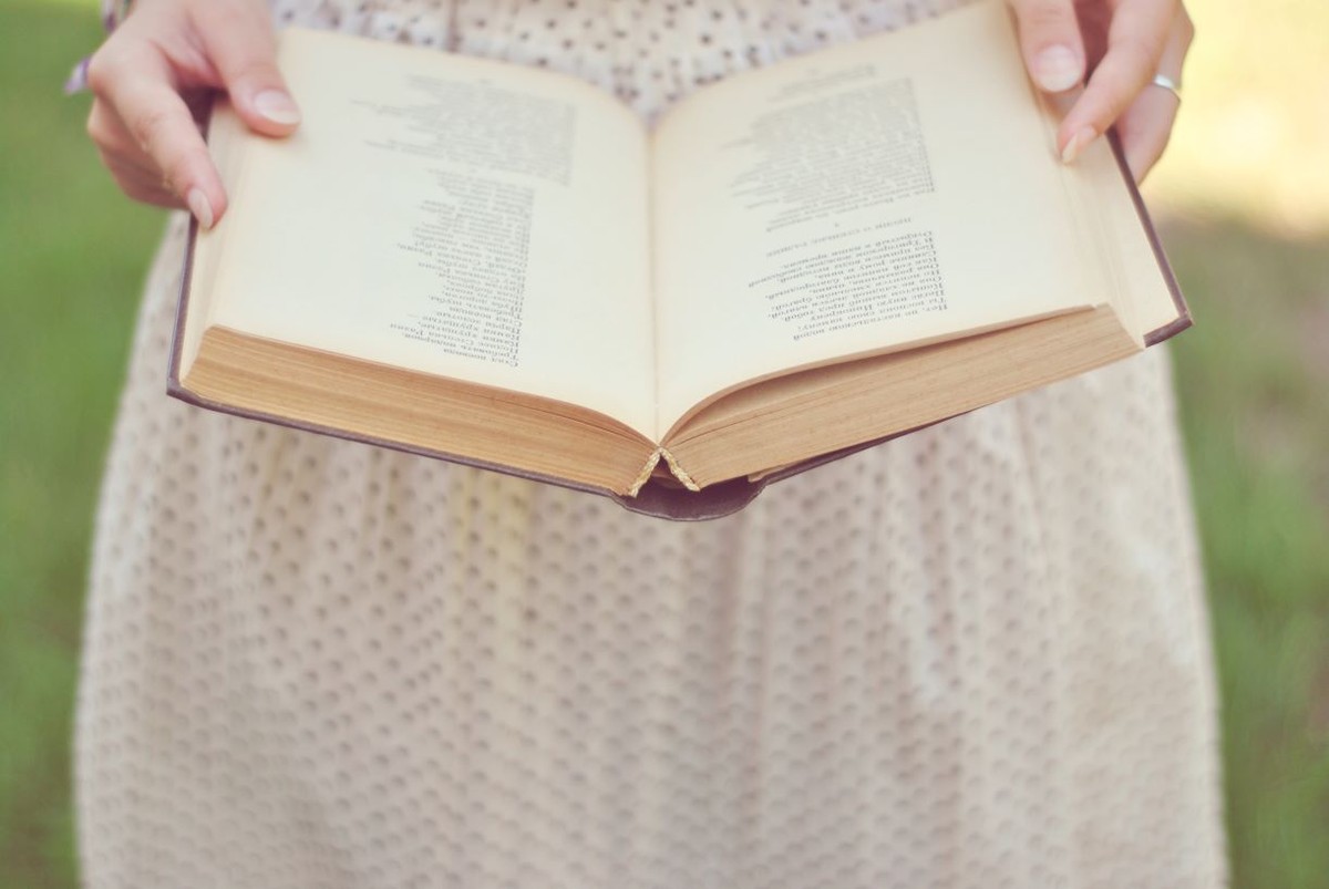 Kobieta trzyma w rękach książkę