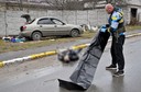 Służby zabierają zwłoki leżące na ulicy w Buczy.