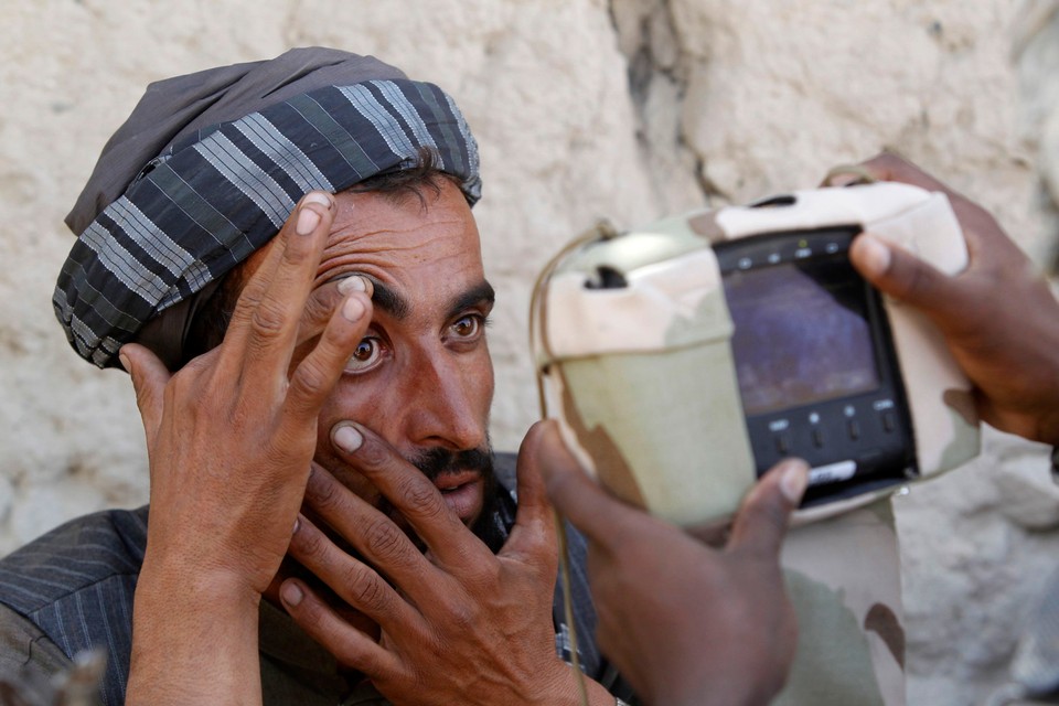 A U.S. soldier from 3rd Platoon, Bravo Company, 1-22 Infantry Batallion takes a retina scan of a villager during a patrol in Shingkay village in Kandahar province