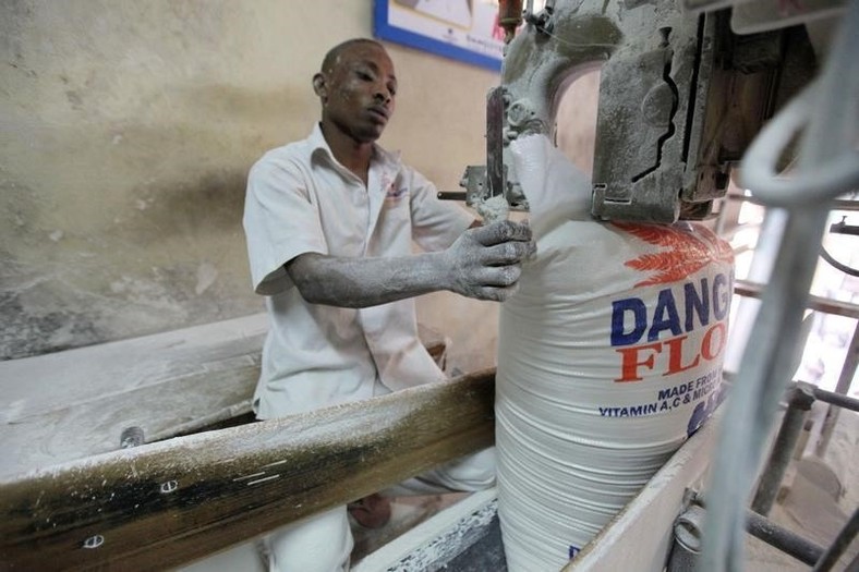 A worker operates a bag-sealing machine at the Dangote flour mill in Apapa district in Nigeria's commercial capital of Lagos November 13, 2010. REUTERS/Akintunde Akinleye