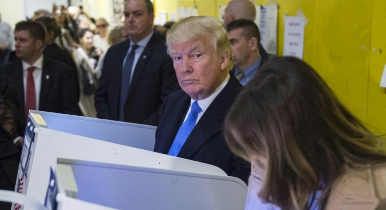 Republican presidential nominee Donald Trump and his wife Melania fill out their ballots at a polling station in a school during the 2016 presidential elections on November 8, 2016 in New York