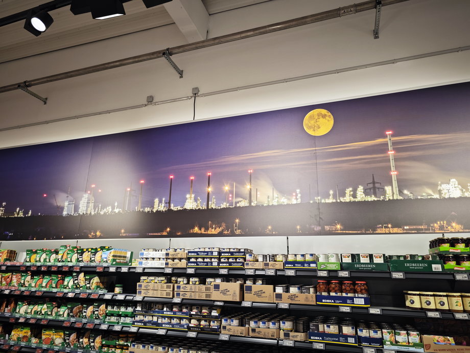 Gigantyczny plakat ze zdjęciem rafinerii góruje nad sklepem