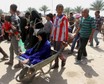 A woman is transported in a wheelbarrow as displaced Sunni people, who fled the violence in the city of Ramadi, arrive at the outskirts of Baghdad