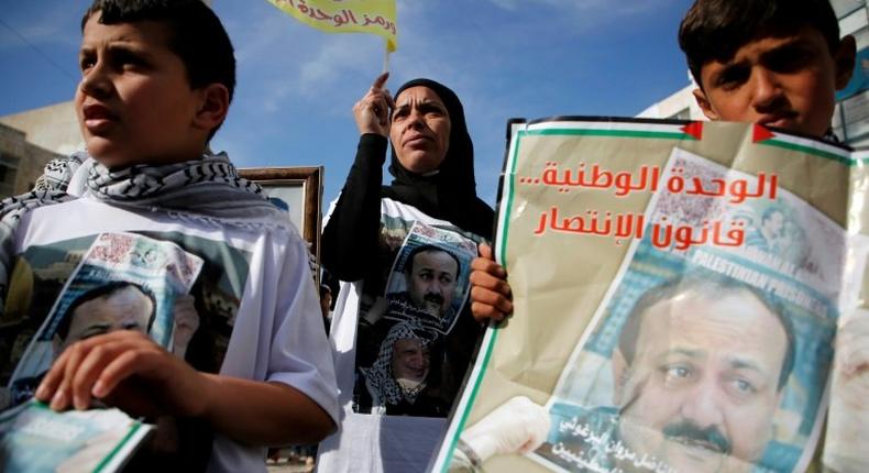 Palestinians hold portraits of Palestinian leader and prominent prisoner Marwan Barghouti, during a rally in the West Bank city of Ramallah in support of prisoners on hunger strike in Israeli jails on April 24, 2017