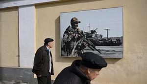 Pedestrians walk past a poster honoring the Russian Armed Forces in Moscow on April 2, 2024.NATALIA KOLESNIKOVA/AFP via Getty Images