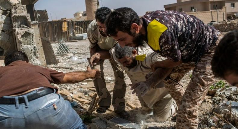 Fighters loyal to Libya's Government of National Accord help a wounded comrade who was shot by an Islamic State (IS) group sniper on the western frontline in Sirte