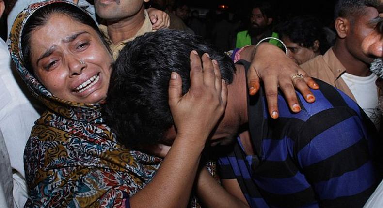 A woman comforts a man mourning for a relative killed in a bomb explosion in Lahore, Pakistan