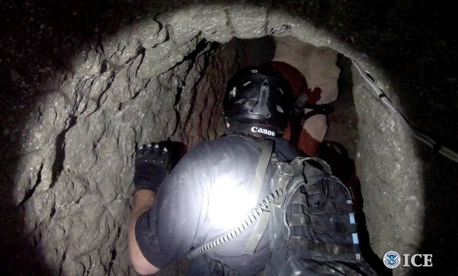 A Homeland Security agent enters a tunnel used to smuggle drugs between the US and Mexico in this photo released on October 31, 2013, by the US Immigration and Customs Enforcement Department (ICE). The tunnel linked an industrial park in Otay Mesa, California, with Tijuana, Mexico, and featured both rail and ventilation systems.