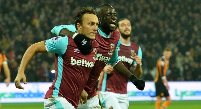 West Ham United's English midfielder Mark Noble (L) celebrates after scoring the opening goal from the penalty spot during a match against Hull City at The London Stadium on December 17, 2016