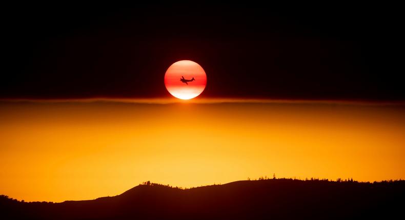 An airplane flies past the sun during a California wildfire in Yosemite National Park on July 15, 2018.