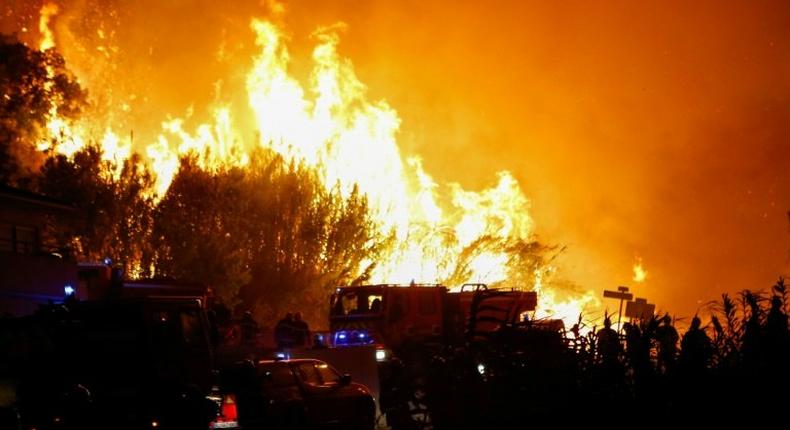 Firefighters work to put out a fire in Biguglia, on the French Mediterranean island of Corsica