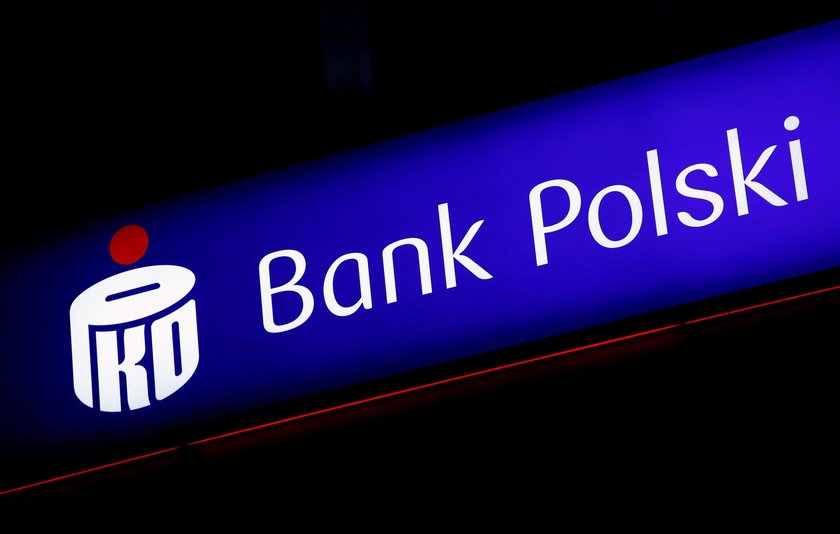 A woman walks outside an entrance to the PKO BP bank headquarters, Poland's largest lender, in Warsa