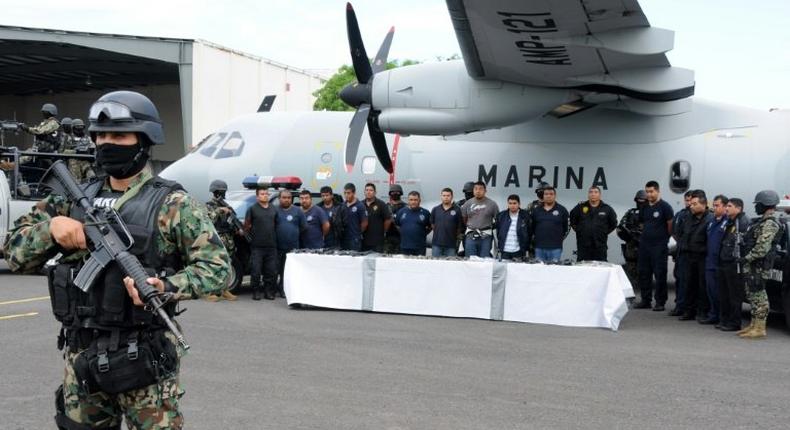 Mexican marines escort a group of alleged municipal policemen working for the Zeta cartel, five members of the same cartel and nine escaped inmates, in Veracruz, in 2011