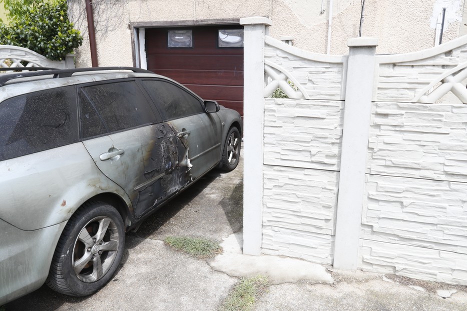 Az udvaron mindenhol a robbanás és a tűz nyomait látni, ez a parkoló autó is megsérült a lángoktól.  A gyilkos valószínűleg a nyomokat próbálta így  eltüntetni / Fotó: Fuszek Gábor