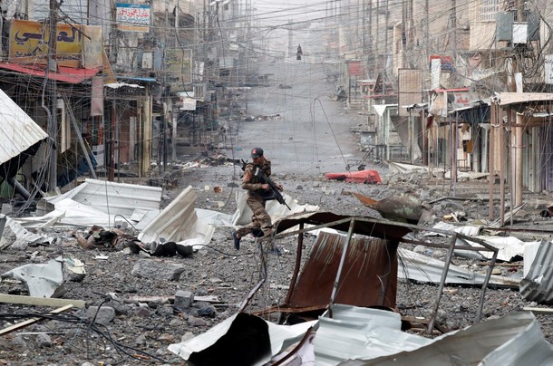 An Iraqi special forces soldier runs across a street during a battle with Islamic State militants in