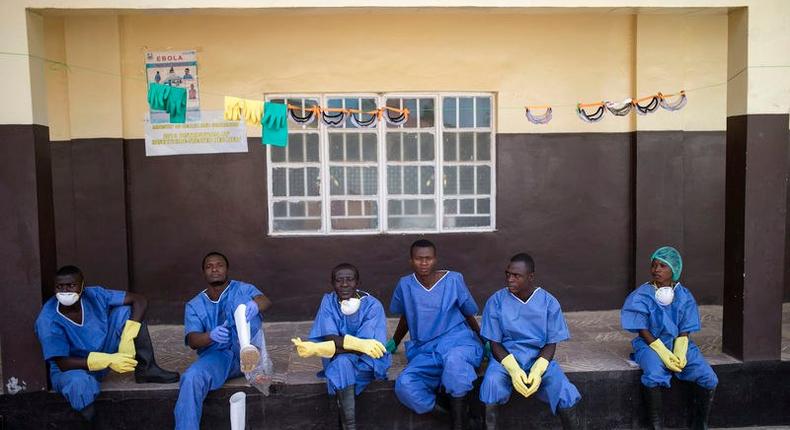 Ebola health workers rest outside a quarantine zone at a Red Cross facility in the town of Koidu, Kono district in Eastern Sierra Leone December 19, 2014.  
REUTERS/Baz Ratner