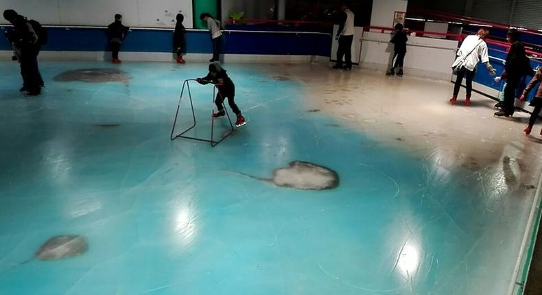 People skate on an ice rink with 5,000 frozen dead fish inside at the Space World amusement park in Kitakyushu, southwestern Japan