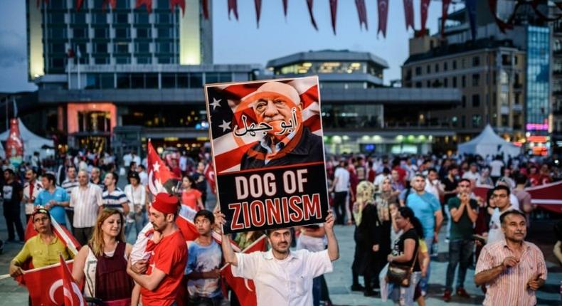 A pro-Erdogan supporter holds a portrait of US-based cleric Fethullah Gulen during a rally against the military coup in Istanbul on July 25, 2016