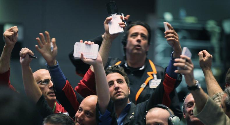 Traders signal offers in the Standard & Poor's 500 stock index futures pit at the CME Group following the Federal Reserve meeting September 21, 2011 in Chicago, Illinois.
