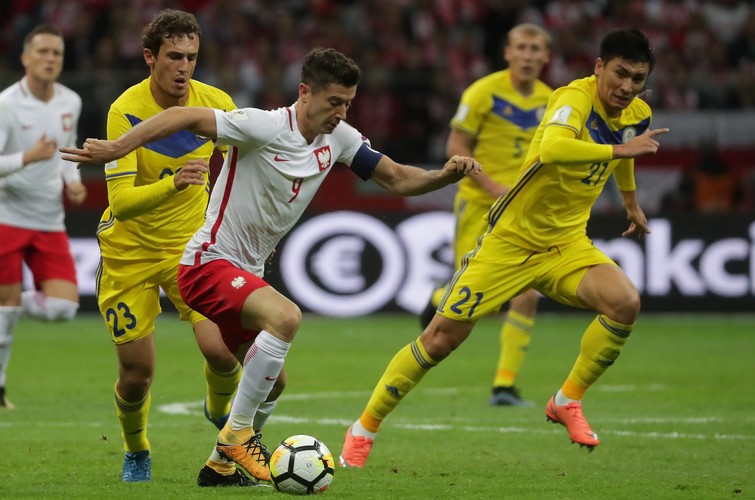 Robert Lewandowski (C) oraz Juri Łogwinenko (L) i Abzał Biejsiebiekow (P)