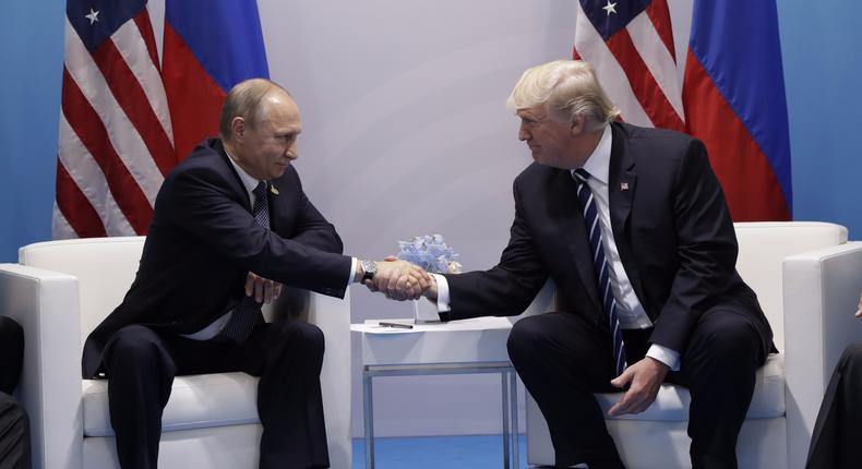 Donald Trump and Russian President Vladimir Putin pose for photos before meeting privately on Friday in Germany.