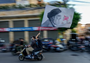 Pristalica Hezbolaha sa zastavom na kojoj je lider Hezbolaha Hasan Nasralah u Bejrutu