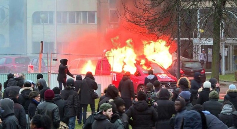 Image grab taken from an AFPTV video shows a van of radio station RTL burning during clashes on the edge of a rally in Bobigny, outside Paris on February 11, 2017 to denounce police brutality after a black man was allegedly raped