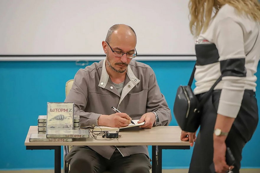 Daniił Tulenkow podpisuje swoją książkę podczas spotkania autorskiego w rodzinnej Wierchniajej Pyszmie