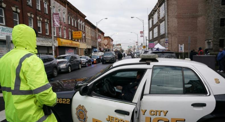Police gather evidence a day after a deadly shooting at a Jewish deli in the New York suburb of Jersey City
