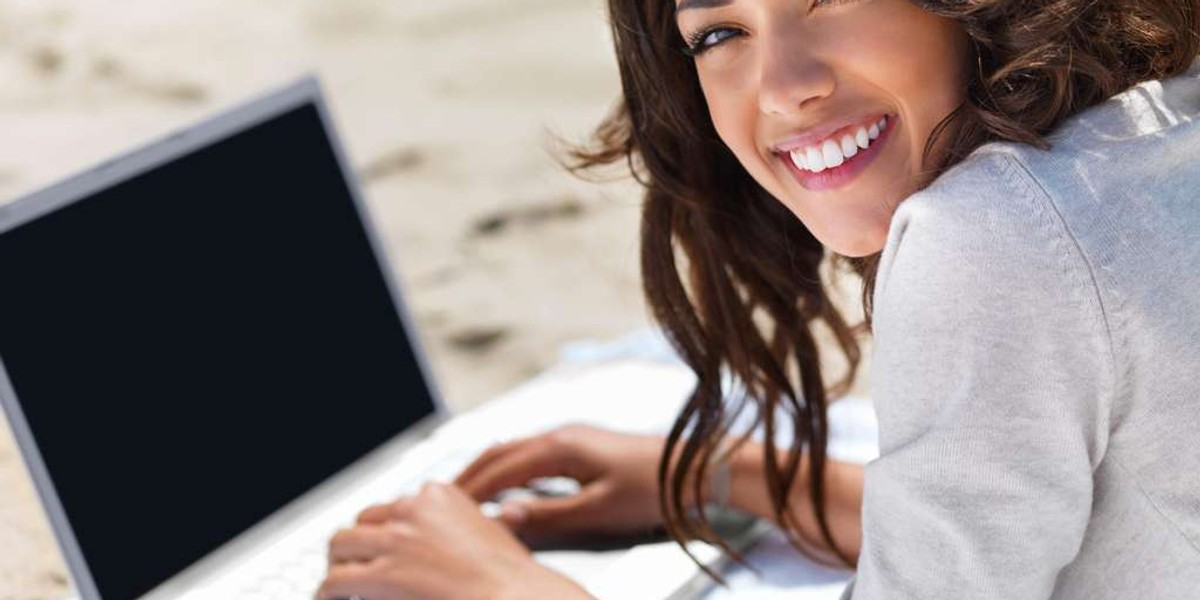 Closeup of a laughing young lady sitting on floor with laptop on