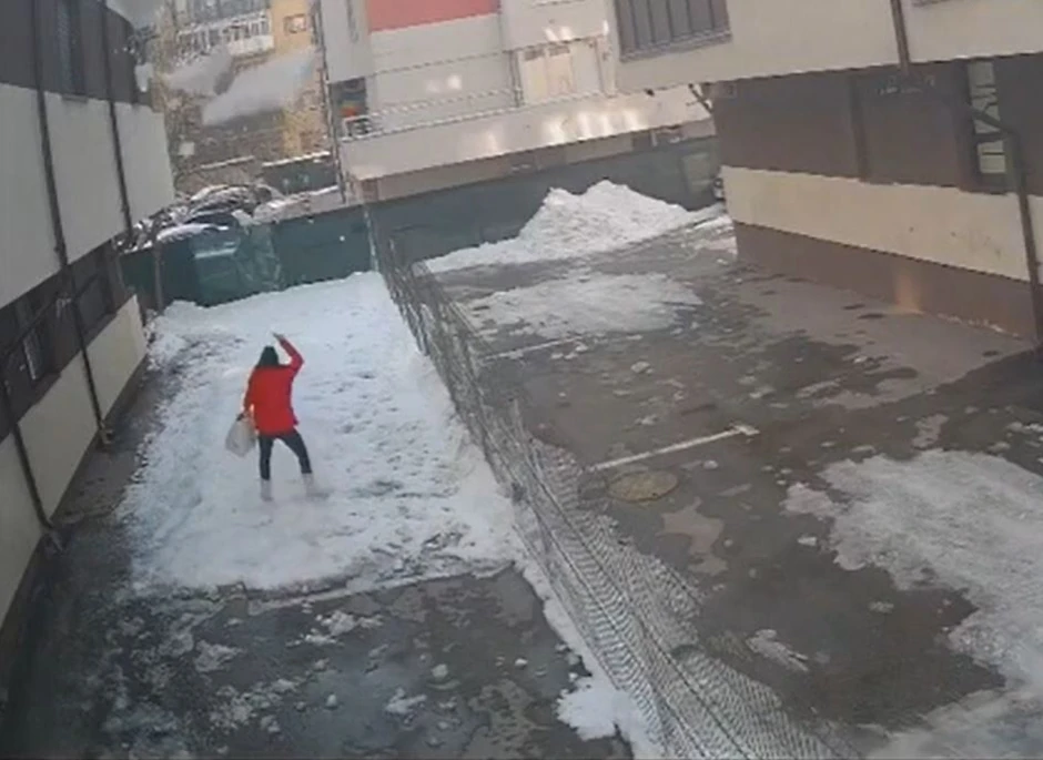 Žena gleda u sneg koji pada na nju