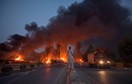 A local resident stands on the street median as he watches fuel tankers burn along the GT road in Nowshera, Pakistan