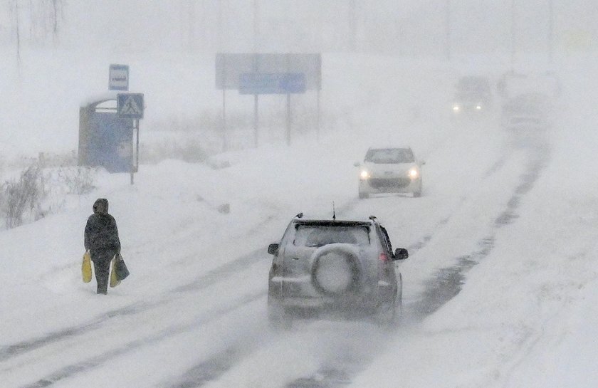 Workers remove snow in a street in Moscow