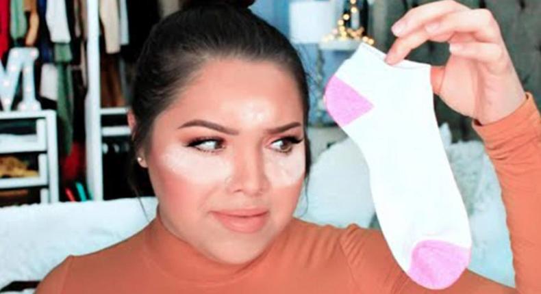 Youtuber shows how to apply foundation using socks