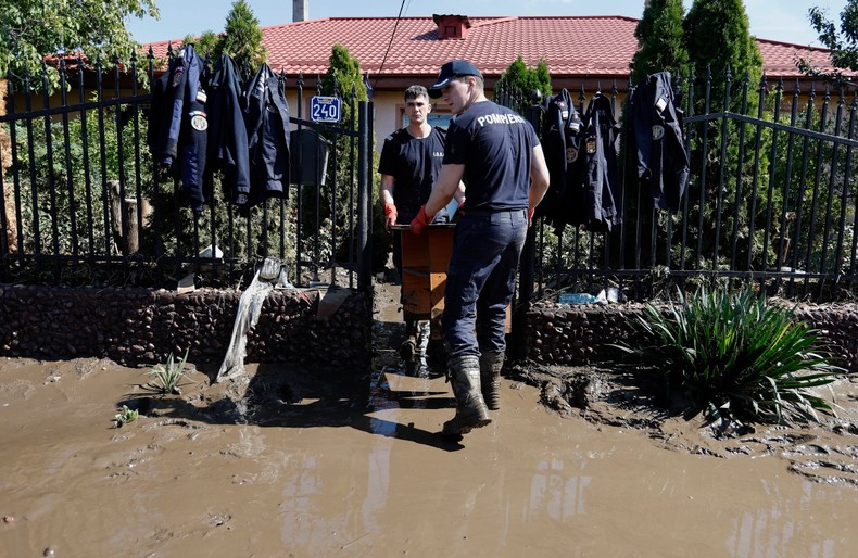 Rumuńscy ratownicy niosą meble przed zalaną szkołą w dotkniętej powodzią wiosce Pechea niedaleko miasta Galati w Rumunii, 16 września 2024 r.