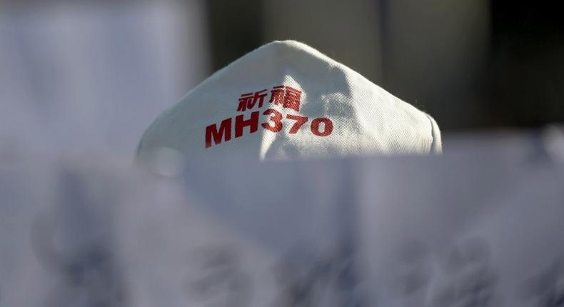 A family member of a passenger onboard Malaysia Airlines flight MH370 which went missing in 2014 holds a banner during a gathering in front of the Malaysian Embassy on the second anniversary of the disappearance of MH370, in Beijing, China, March 8, 2016. 