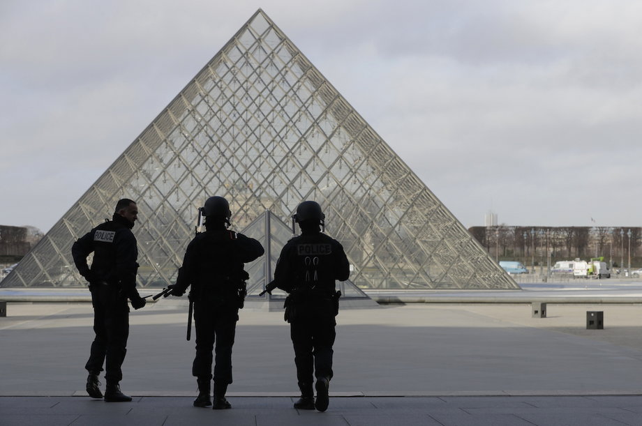 French police officers securing the site near the Louvre Pyramid on Friday. A French soldier earlier shot and wounded a man who was armed with a knife and tried to enter the Louvre museum in central Paris carrying a suitcase, police sources said.