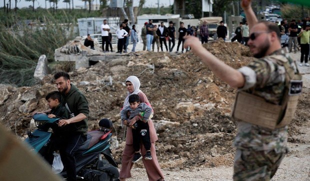 Raseljeni Libanci se pešice vraćaju u domove na jugu zemlje, prolazeći pored razrušenog mosta | Foto: REUTERS/Louisa Gouliamaki