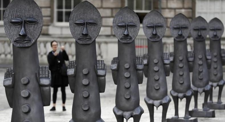 A woman photographs the sculptures Black and Blue: The invisible Man and the Masque of Blackness, by artist Zak Ove, at Somerset House in London, Britain October 4, 2016. 